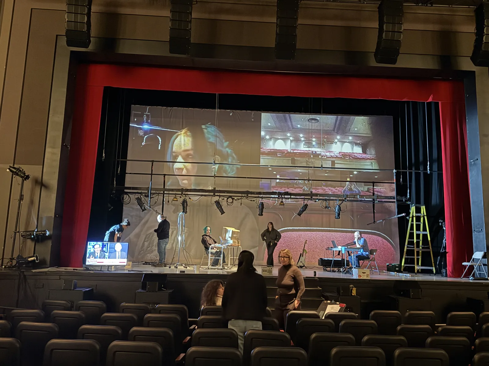 2021: technical rehearsal with the house lights up, a close-up of a face projected beside the game
