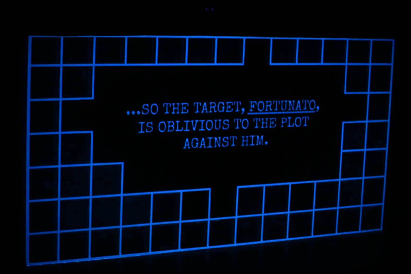 Heist: a projected grid frames the words “…so the target, Fortunato, is oblivious to the plot against him.”